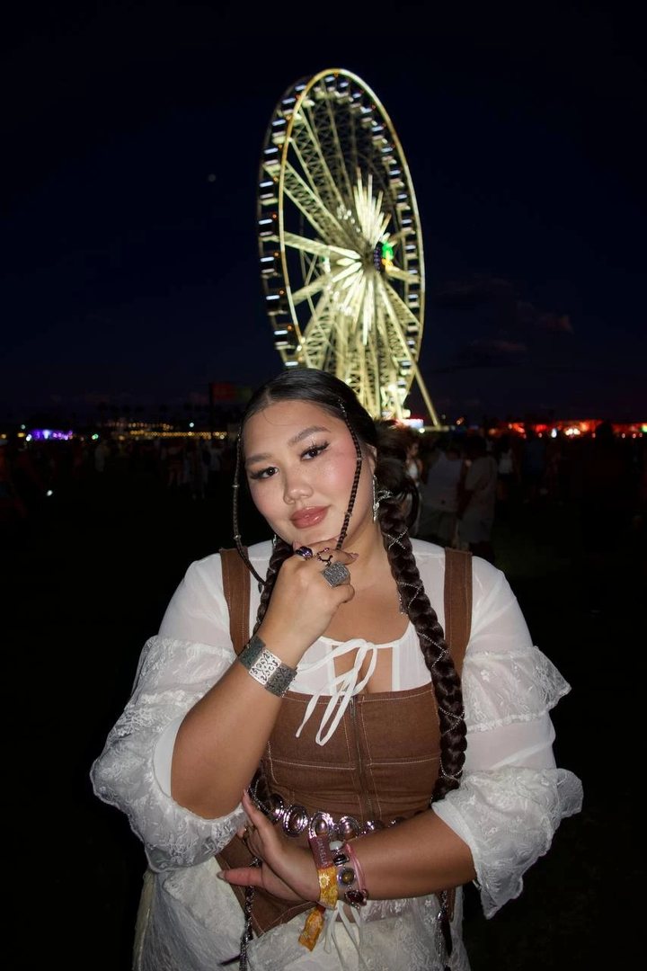 Aru at Coachella at night in front of the Ferris wheel